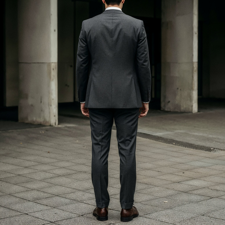 Side view of an elegant dark three-piece suit with subtle pinstripes