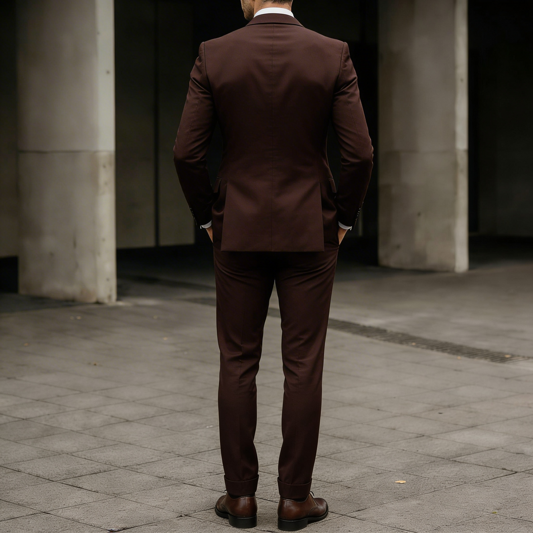 Back view of a man wearing a fitted suit jacket and vest in formal wear