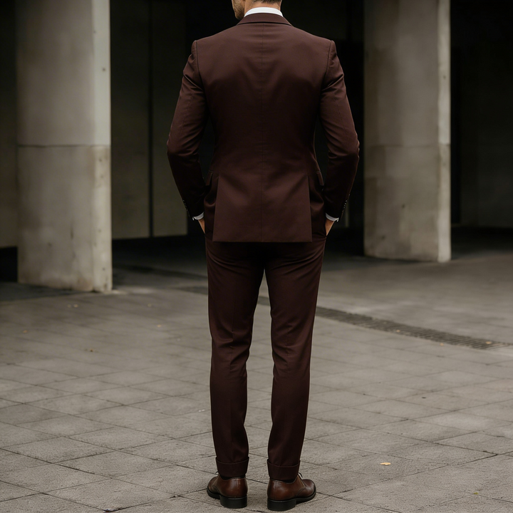 Back view of a man wearing a fitted suit jacket and vest in formal wear