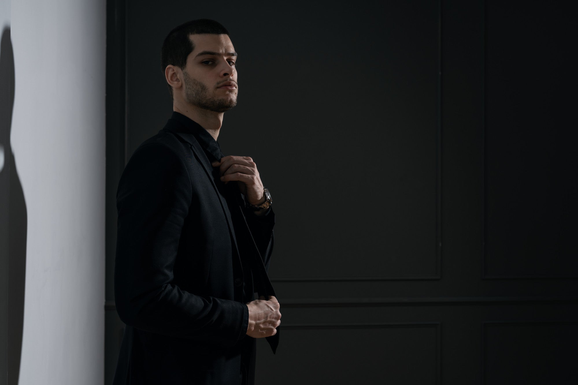 man wearing black suit posing
